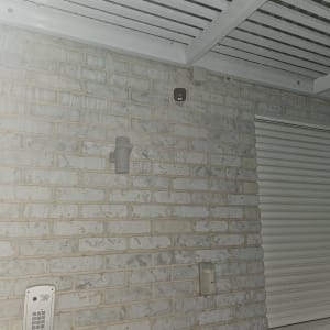 מצלמת אבטחה מותקנת על קיר לבנים חיצוני