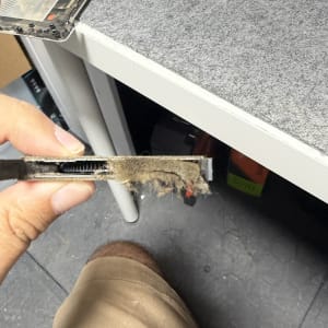 יד מחזיקה חלק מחשב עם אבק על שולחן עבודה
