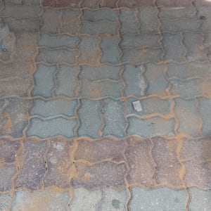 משטח מרוצף באבנים משתלבות חיצוניות בגווני אפור ואדום