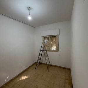 חדר ריק עם סולם וצבע טרי על הקירות