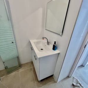 כיור חדש עם ארון ומראה בחדר אמבטיה