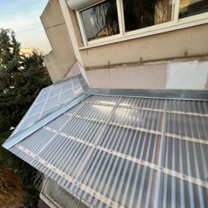 גג מתכת מותקן על מבנה ליד עצים