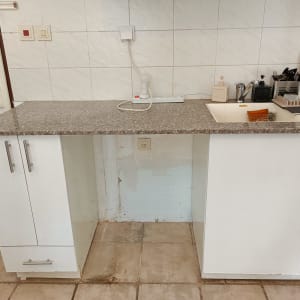 מטבח עם משטח עבודה, כיור וכלי מטבח