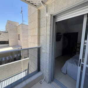 צינור מיזוג אוויר על מרפסת עם דלת זכוכית פתוחה