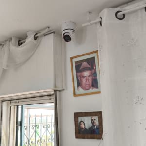 מצלמת אבטחה מותקנת בפינת החדר ליד תמונות על הקיר