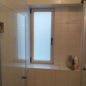 חלון עם זכוכית חלבית ומסגרת לבנה