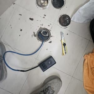 כלים לפתיחת סתימות בצנרת על רצפת חדר אמבטיה