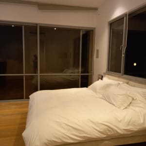 חדר שינה עם מיטה מסודרת ומצעים לבנים