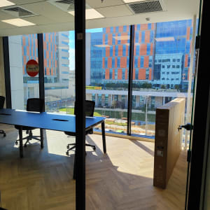 קופסת טלוויזיה גדולה ליד שולחן משרדי וכיסאות