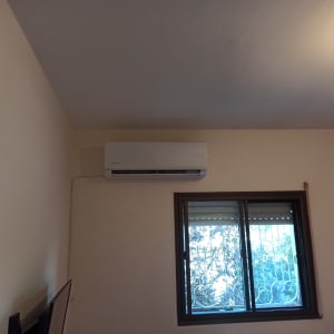 מזגן מותקן על קיר ליד חלון