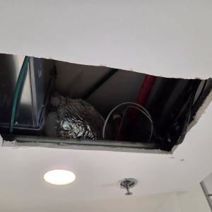 פתח בגבס עם חוטים וצינורות בתקרה