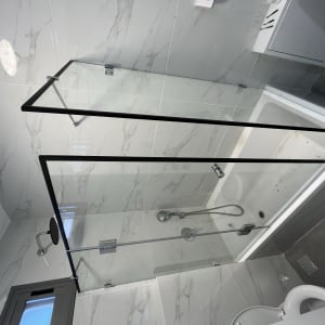 מחיצת זכוכית במקלחת עם מסגרת שחורה