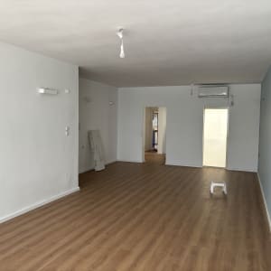 חדר עם רצפת פרקט עץ בהירה וקירות לבנים