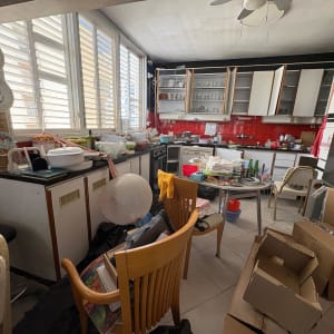 מטבח מבולגן עם כלים וארגזים, מתאים לפעילות של HouseClear.