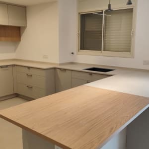 מטבח מודרני עם משטחי עץ ותאורה תלויה