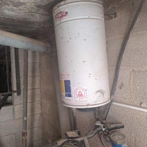 דוד שמש מותקן על קיר עם צינורות וחיבורים
