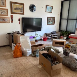 חדר עם קופסאות קרטון, שקיות וציוד ארוז
