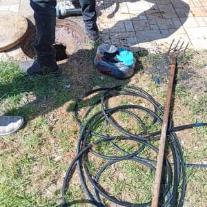 אדם עומד ליד בור פתוח עם צינורות וכלים