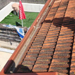 רעפים אדומים עם תעלת ניקוז על גג