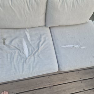 כריות ישיבה קרועות עם כתמים על ספסל עץ