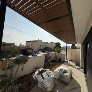פרגולה מעץ מעל מרפסת עם שקי חומרי בניין