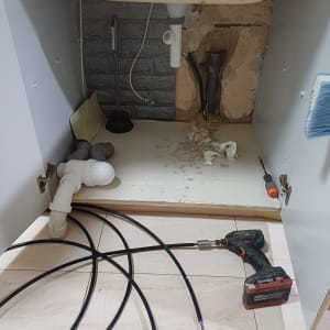 כלי עבודה וצינורות מתחת לכיור במטבח