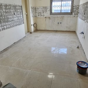 חדר ריק עם קירות מתקלפים וכלי עבודה על הרצפה