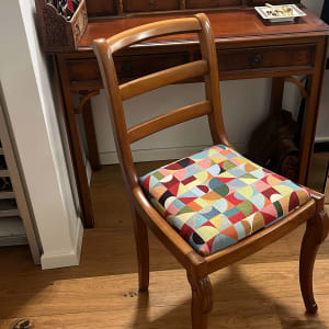 כיסא מרופד בעיצוב צבעוני ליד שולחן עץ