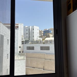 נוף עירוני מבעד לחלון זכוכית עם בניינים מודרניים