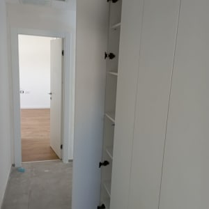 ארון לבן עם דלת פתוחה ומדפים פנימיים