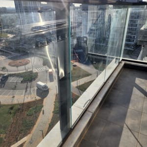 מעקה זכוכית במרפסת עם נוף עירוני