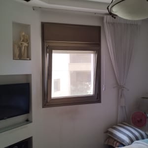 חלון עם תריסים חומים סגורים בחדר שינה