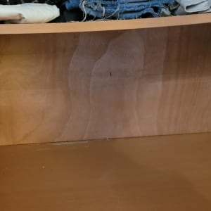 מדף עץ ריק עם בגדים מקופלים למעלה