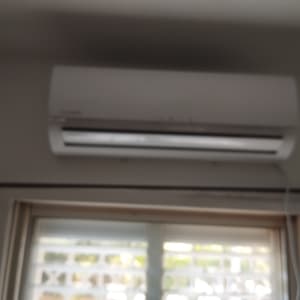 יחידת מיזוג אוויר מותקנת על קיר מעל חלון