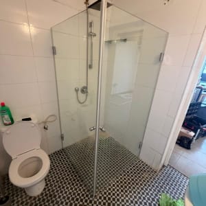 מקלחון זכוכית בחדר אמבטיה עם רצפת אריחים