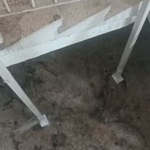 מדרגות מתכת עם מעקה על רקע רצפה כהה