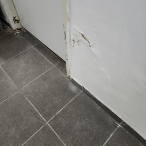 קיר עם סימני רטיבות ונזק ליד דלת