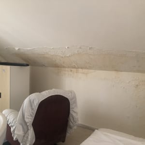 קיר עם נזקי רטיבות ותקרה משופעת