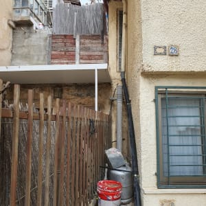 דלי צבע וכלי עבודה ליד קיר חיצוני