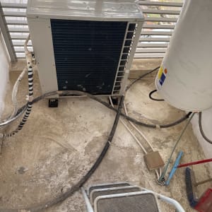 יחידת מזגן חיצונית עם צינורות ומטאטא