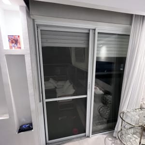 תריסים לבנים סגורים על חלון זכוכית גדול