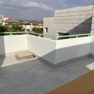 מרפסת עם ריצוף חדש ומעקה ירוק