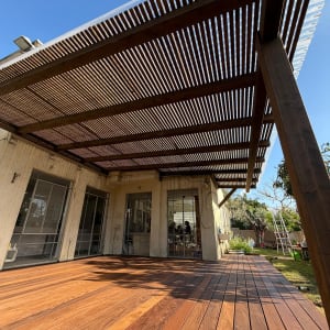 פרגולה ודק עץ בחצר בית