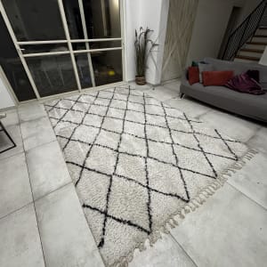 שטיח נקי על רצפה ליד ספה וכריות צבעוניות