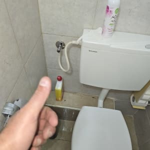 אסלה עם בקבוק חומר ניקוי ומיכל מים