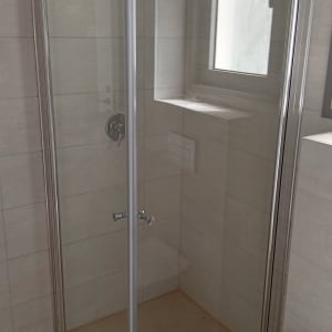 מקלחון זכוכית עם ראש מקלחת מתכתי