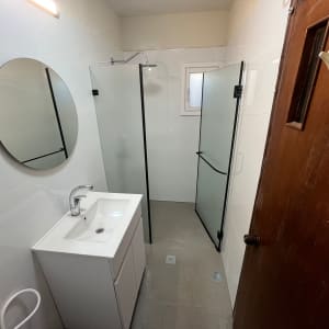 חדר אמבטיה משופץ עם מקלחון וכיור חדש