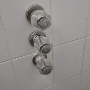 ברזים מותקנים על קיר אריחים בחדר אמבטיה