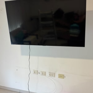 טלוויזיה תלויה על קיר עם כבלים גלויים