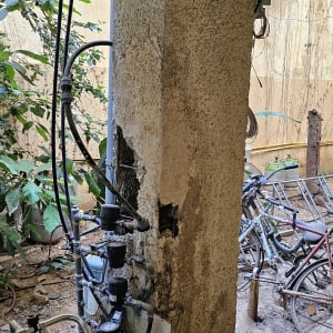 עמוד בטון עם צינורות ומדי מים בחצר